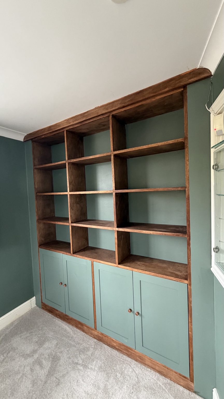 Bespoke shelving with green shaker cabinetry and timber detailing